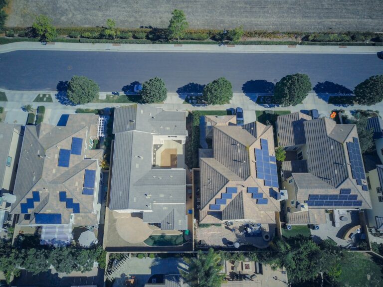 aerial view of houses with solar panels along the road